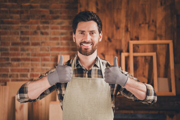 Wall Mural - Photo of attractive cool craftsman dressed uniform showing two thumbs up indoors garage home house