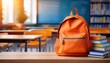 © Eli - Orange School Backpack with Books on the Table in Blured Class Room Background. Back to School Concept. Banner with Copy Space.