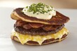 © Serjio - Hamburguesa con carne a la parrilla, tocino, queso derretido y una base de pan de papa, decorada con crema y cebollino.