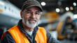 © Keitma - Portrait of man aircraft maintenance mechanic wearing a safety vest in front of a plane under repairs
