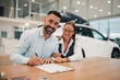 © Zamrznuti tonovi - Couple poses with signed contract, celebrating new car deal.