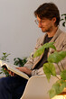 © ADDICTIVE STOCK - Man reading a book surrounded by green indoor plants