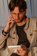© ADDICTIVE STOCK - Young man focused on digital tablet indoors