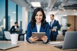 © Michael - Smiling Young Hispanic Businesswoman Working with Tablet in Trendy Office