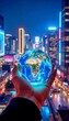 © Violetta - Person holding a glowing globe in hand with city skyline background at night