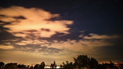 Wall Mural - time lapse of day and night of the starry cloudy sky over the city