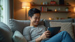© Анатолий - Man Enjoying a Video Call on a Tablet While Lounging in a Cozy Living Room