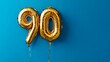 © Pangestu - Banner with number 90 golden balloon with copy space. thirty years anniversary celebration concept on a blue background
