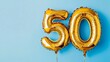 © Pangestu - Banner with number 50 golden balloon with copy space. thirty years anniversary celebration concept on a blue background