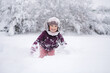 © Aleksandr - Little girl wearing a cozy winter outfit, happily exploring deep snow. The pure white snow surrounds her, creating a dreamy winter scene full of childhood wonder