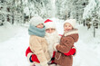 © lizavetta - Santa Claus with children in a snowy forest.