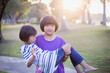 © chaunpis - Cute children play in the park at sunset.