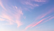 © pixdots - Pastel pink clouds drift across a serene blue sky at dawn or dusk, creating a breathtaking and dreamy spectacle.