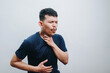© IgnatiusHarly - an asian young man coughing and holding his neck