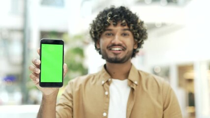 male customer shows green screen phone smartphone standing in shopping center mall store or airport for mockups and advertising discount sale promotion Chroma key for mobile app application indoor