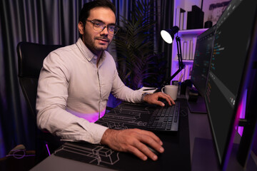 Working smart IT developer analyzing data software development on two pc screen, creating application program updated version online website page system online at neon light cyber office. Surmise.