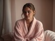 © Leopard - A young woman wrapped in a cozy pink robe, exuding warmth and comfort, her relaxed expression reflecting a calm and peaceful moment indoors