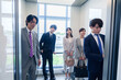 © maroke - オフィスでエレベーターに乗るビジネスパーソン