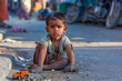 © Indian People Images - A little Indian boy sits on the curb, his toy car forgotten beside him, his boredom evident in the way he kicks at the dirt.