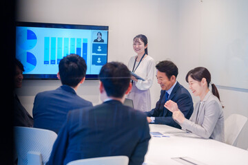 Poster - 会議室でプレゼンをする若い女性