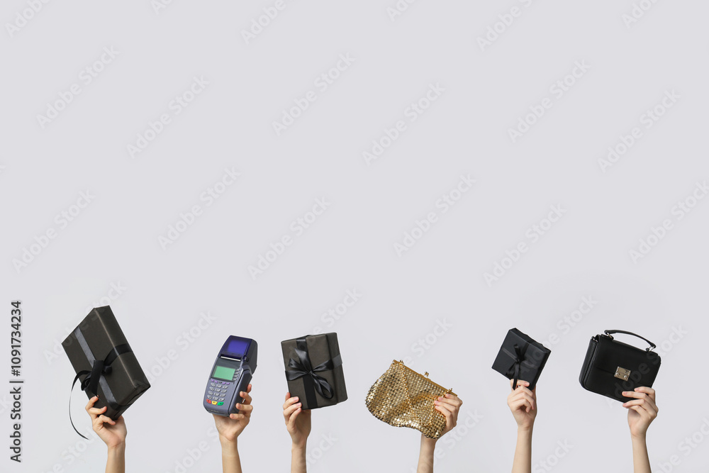 Female hands with gift boxes, payment terminal and stylish bags on grey background. Black Friday Sale