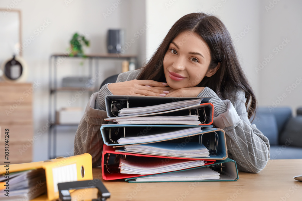 Beautiful businesswoman with folders at table in office