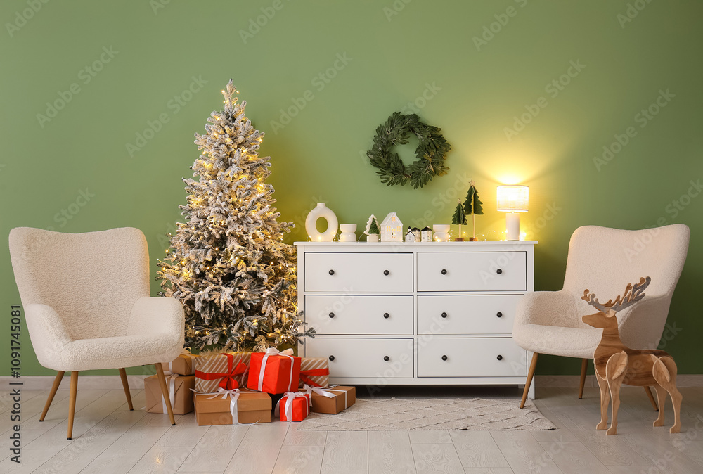 Interior of living room with commode, armchairs and glowing Christmas tree
