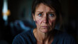 © vejaa - Portrait of middle aged woman with bruises on her face looking sadly in dark room. Social isolation, harassment, domestic violence, physical assault, gender-based violence victim
