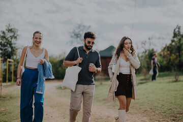 Wall Mural - A group of friends strolls through a scenic outdoor setting, enjoying a relaxed day. With smiles and casual attire, they revel in nature's tranquility and companionship.