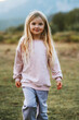 © EVERST - Cute girl kid walking outdoor 5 years old child portrait blonde hair happy smiling, family vacations travel lifestyle, children fashion