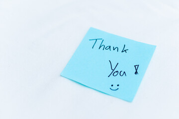 Poster - Thank you note on blue sticky pad office setting personal gesture clean environment close-up view concept of appreciation in business