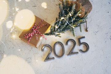 Wall Mural - New Year's lights gold and dark red colors bokeh background with glowing number 2025 and fireworks. Happy New Year concept for 2025.