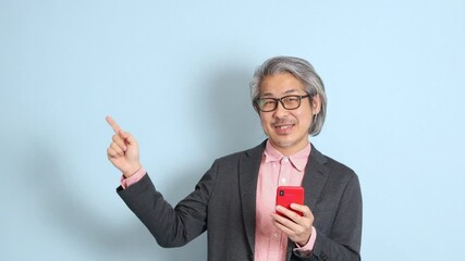 Wall Mural - The senior Asian man standing on the blue background.