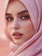 © Yamato - A close-up portrait of a woman wearing a pink hijab against a soft background.
