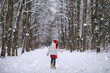 © alexkich - A winter fairy tale, a young mother and her daughter ride a sled in the forest.