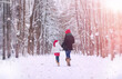 © alexkich - A winter fairy tale, a young mother and her daughter ride a sled in the forest.