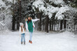© alexkich - Young family for a walk. Mom and daughter are walking in a winter park.