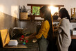 © Wavebreak Media - asian female teenager washing dishes while grandmother prepares meal in cozy kitchen, at home