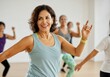 © Alexandra - Happy mature woman dancing with energy in a zumba class, promoting active lifestyle and wellness in older age