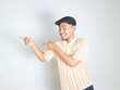 © vicky - young Asian man wearing a striped polo shirt, pointing to the side with an excited and happy face