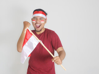 Wall Mural - Excited young Asian men celebrate Indonesian independence day on 17 August by holding the Indonesian flag isolated over white background