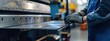 © Alpa - Workers hand bend metal sheets using machines. Modern steel plate cutting industry