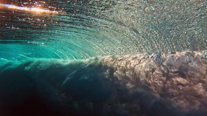 Wall Mural - Ocean wave breaks on a shore in the Maldives on sunset