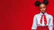 © Trushchenko_O - Young woman with red hair and a red tie stands in front of a red background. Concept of confidence and style, as the woman is dressed in a school uniform and has her hair styled in pigtails