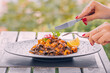 © EdNurg - A woman enjoys linguine with seafood, mainly mussels, in a restaurant overlooking the Adriatic Sea, blending culinary delight with a scenic coastal view.