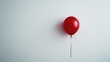 © Aisha - A single red balloon floating against a white minimalist background