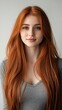 © Valentyna Prudnikova - Portrait of a young woman with striking long red hair and green eyes, wearing a simple gray top against a neutral background, exuding natural beauty.