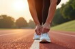 © Aksana - Runner tying shoelaces on track during sunrise, athletic preparation and fitness motivation concept