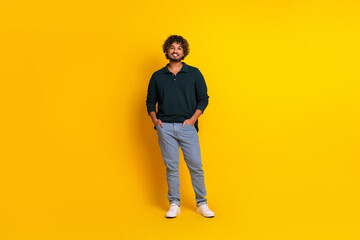 Young man smiling in casual attire on a vibrant yellow background. Ideal for advertising, promotion or lifestyle themes.