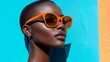 © Joachim - An assertive individual wearing vibrant orange sunglasses stands against a blue wall, symbolizing boldness, confidence, and a celebration of modern style.